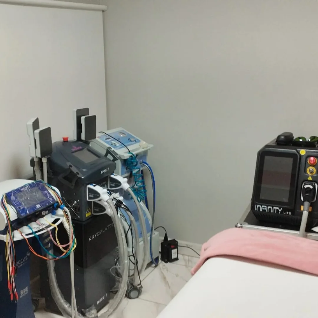 Sala de atendimento com os aparelhos enfileirados e a maca coberta por uma manta rosa