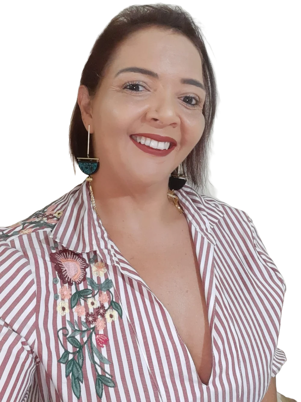 Cris Souza sorrindo, de camisa listrada com flores bordadas e brincos grandes